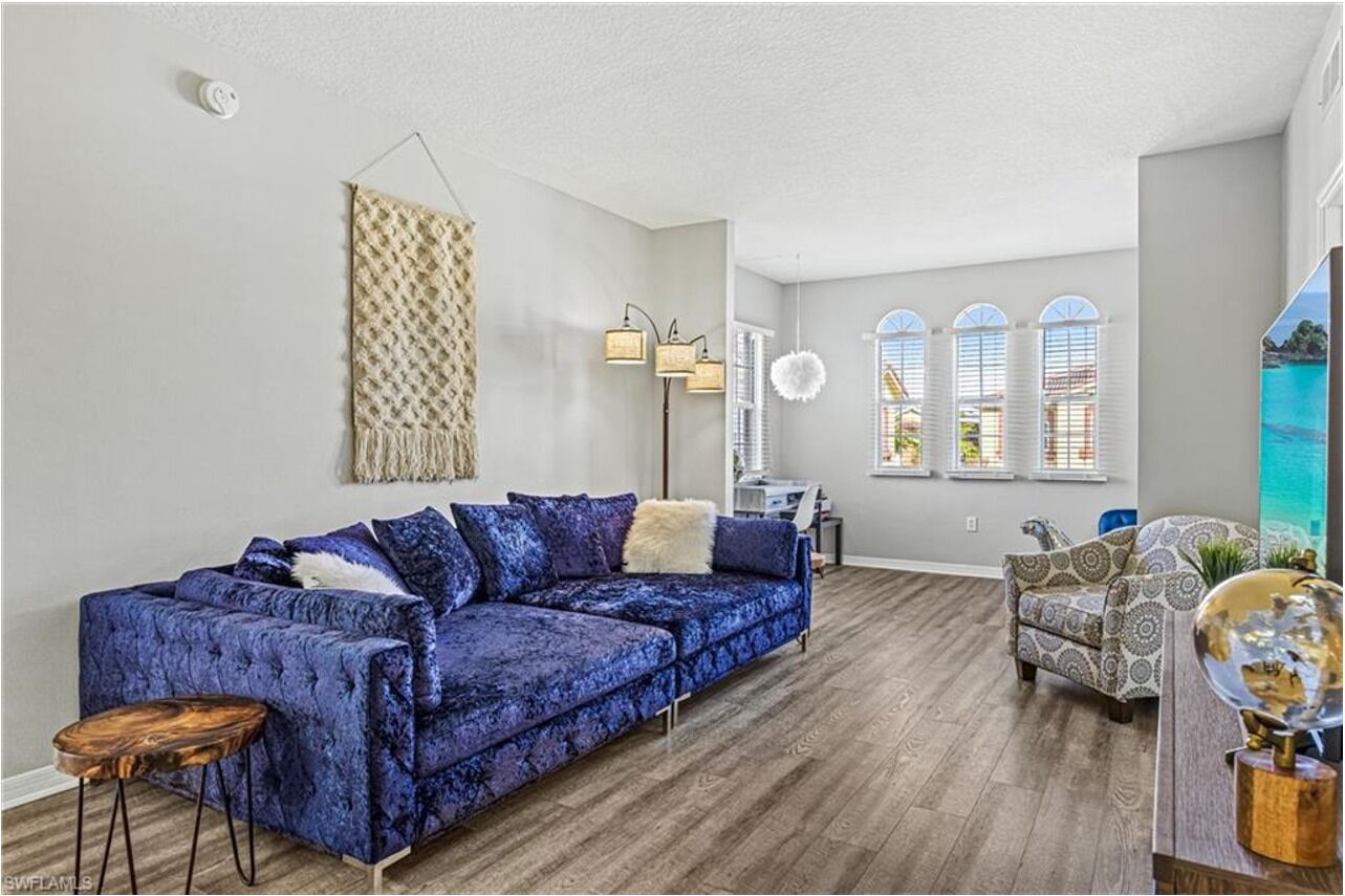 A living room with a blue sofa, patterned armchair, and a globe on a wooden side table.