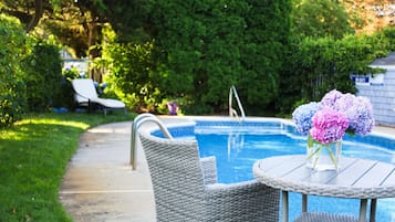 Relax by the serene pool surrounded by lush greenery and a beautifully manicured garden.