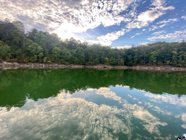A calm lake reflecting the sky and trees.