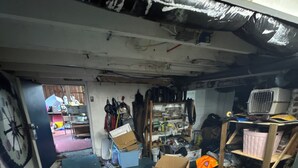 Un almacén desordenado con cajas, estanterías y diversos objetos.