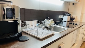 Una cucina moderna con una macchina per il caffè, un espositore per piatti e un lavandino.