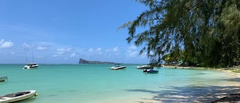 Una playa cerca, sillas reclinables de playa, toallas de playa