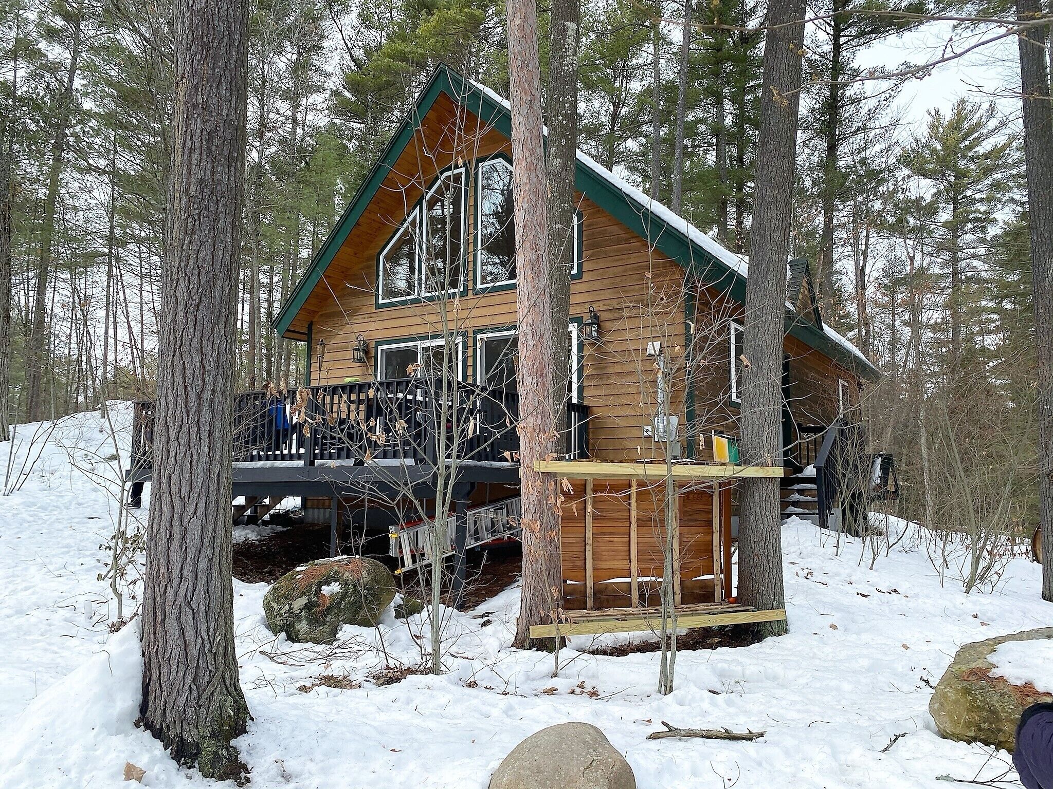 Een chalet met een houten gevel, een balkon en een besneeuwde omgeving.