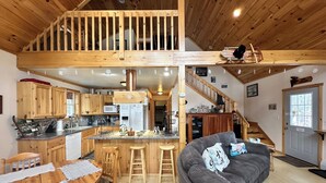 Une cuisine spacieuse dotée de meubles en bois, d’un îlot central et d’un coin repas avec une table et des chaises en bois.