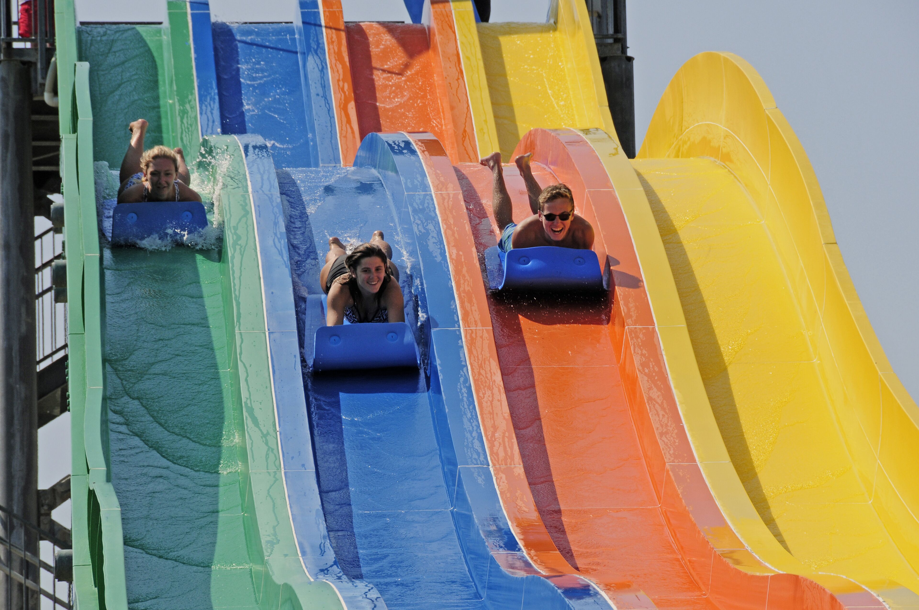 A water slide with multiple lanes in green, blue, orange, and yellow colors.