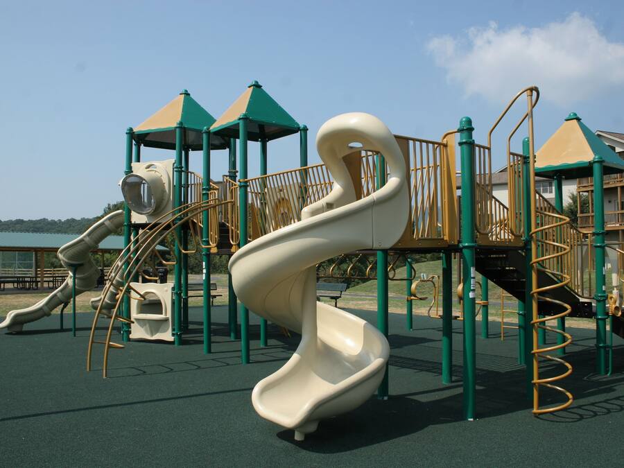 Un parque infantil con un tobogán en espiral y estructuras para escalar.