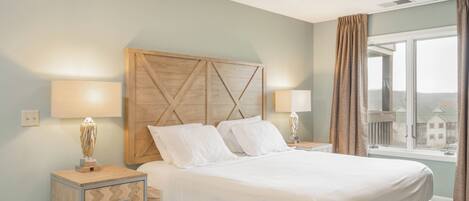 Una habitación de hotel con cama, dos lámparas de noche, una mesita de noche con lámpara y una ventana con cortinas.
