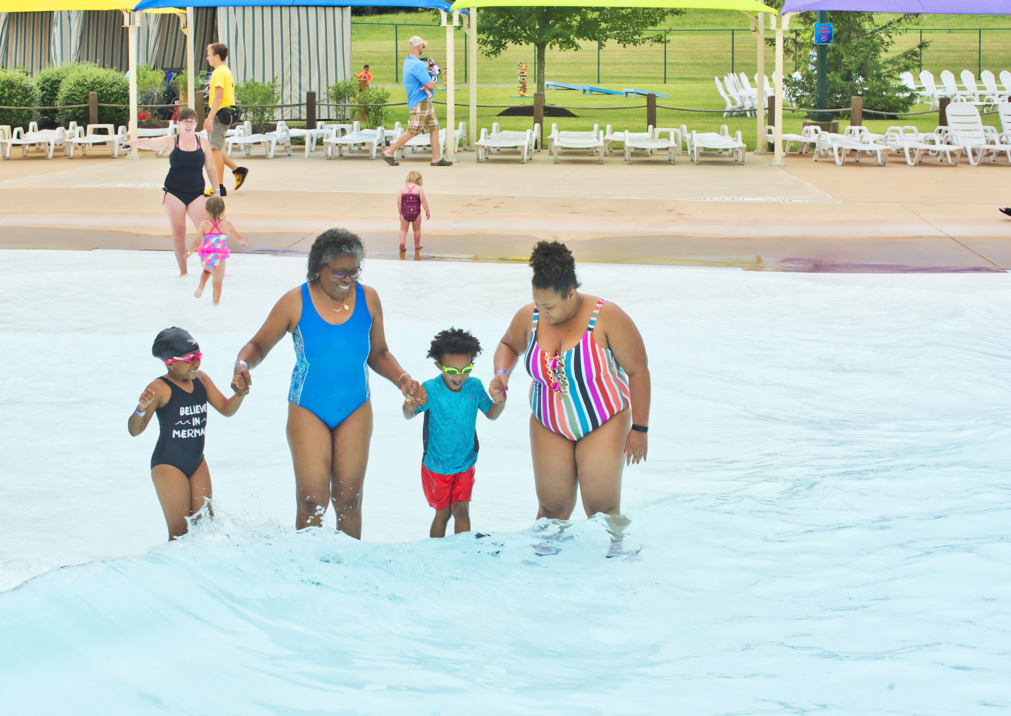 A water park with a pool area, lounge chairs, and a covered seating area.