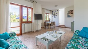 Amplia sala de estar con sofá, mesa de comedor y televisor.