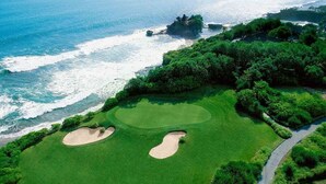 A golf course with two sand bunkers, a water body, and dense greenery. - 30% off! 8-3BR En Suites,Ultra Modern Best Of The Best In SeminyaksBest Location (Seminyak)