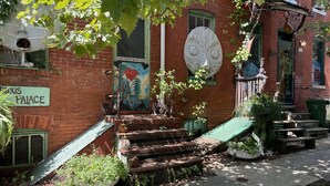 A building with a sign reading 'HOUSE PALACE,' a mural on the wall, and a large, round, white object resembling a face. - Downtown Home - Close to Topgolf, Ravens Stadium, Orioles Park, UM Baltimore (Baltimore)