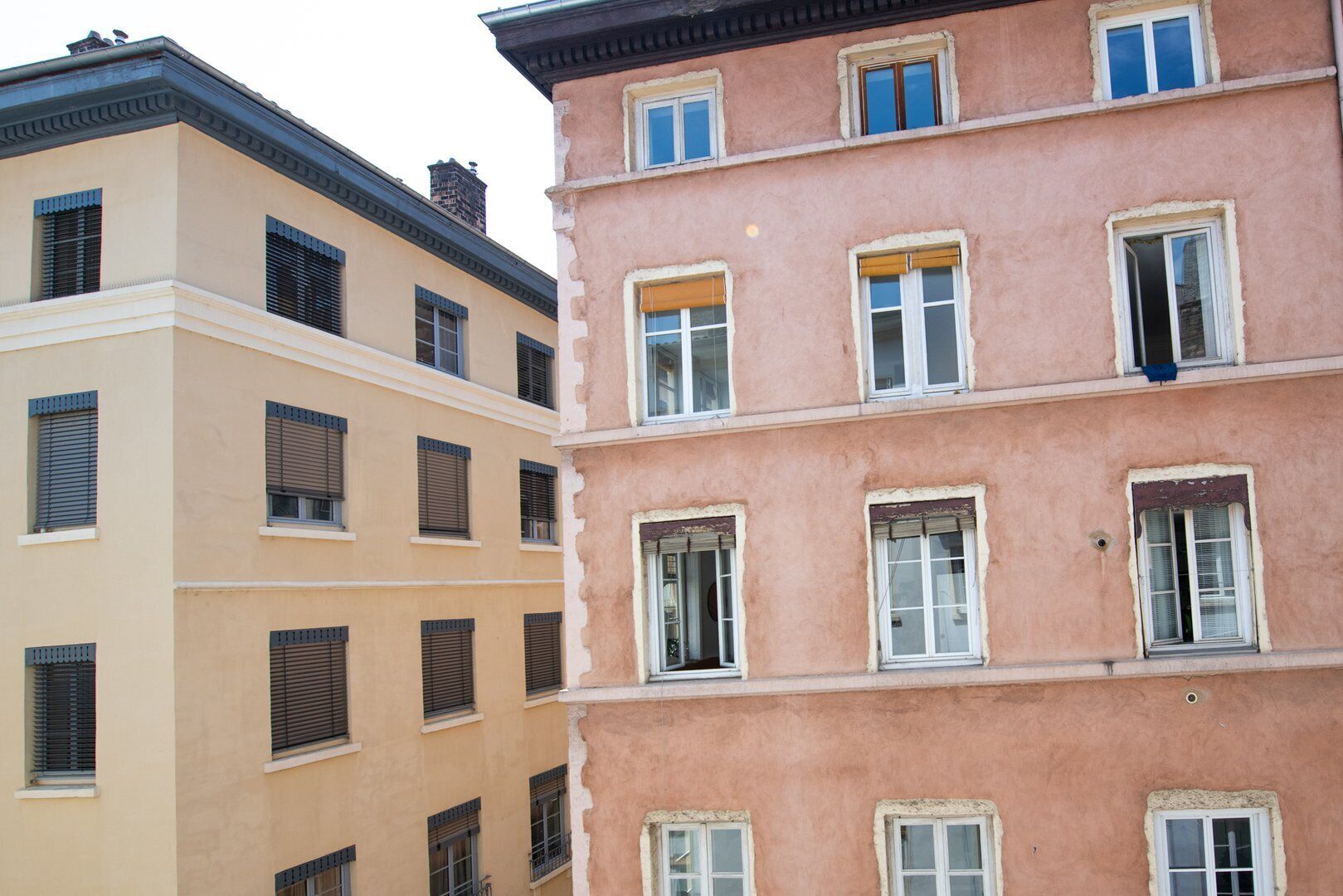 Ein mehrgeschossiges Gebäude mit beiger und rosa Fassade.