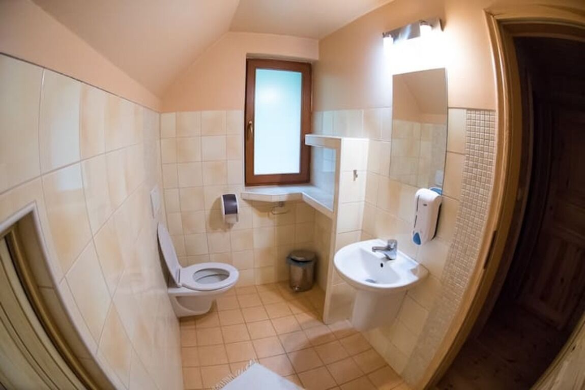 Une petite salle de bain avec des toilettes, un lavabo et un miroir.