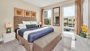 Une chambre d’hôtel avec un grand lit, une table de chevet avec une lampe, une fenêtre avec des rideaux et une vue sur l’extérieur.