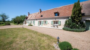 A two-story stone house with a gravel driveway, green shutters, and a well-maintained garden. - Longère classée 4 étoiles - piscine  – Ambillou (Ambillou)