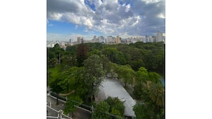 A cityscape with a park area featuring a paved walkway and trees. - Luminosidade, in front of Parque da Luz / 5 minutes from the Metro. (São Paulo)