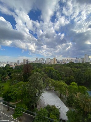 A cityscape with a park area featuring a paved walkway and trees.