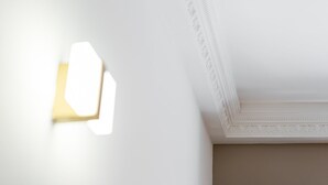 Eine weiße Decke mit dekorativer Stuckleiste und einer eingelassenen Lichtleuchte.
