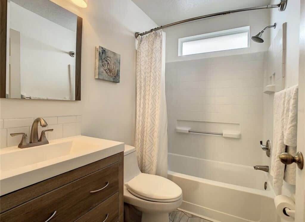 Une salle de bain avec douche, toilettes et lavabo.