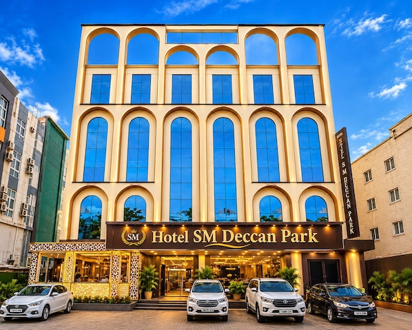 A hotel with a prominent entrance, multiple windows, and a clear sky.