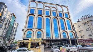 Un hotel de varios pisos con amplias ventanas de arco y un letrero que dice 'Hotel Kinaragoda'.