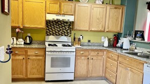 A kitchen with wooden cabinets, a stove, and a microwave.