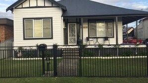 A two-story house with a dark roof and white siding. - Cute country cottage in Cessnock (Cessnock)