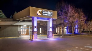 Un hôtel Comfort Inn & Suites doté d’une entrée moderne, de piliers en pierre et d’une façade bien éclairée.