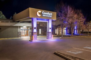 Un hôtel Comfort Inn & Suites doté d’une entrée moderne, de piliers en pierre et d’une façade bien éclairée.