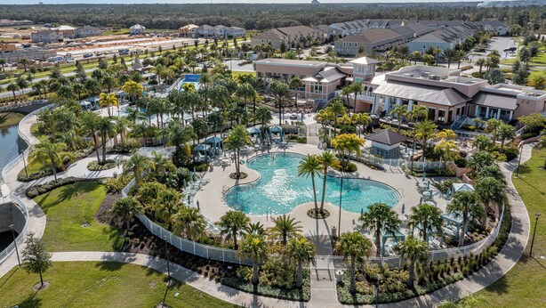 Un complexe hôtelier doté d’une piscine centrale, de palmiers et offrant une vue sur les environs.