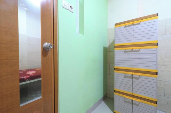 Ein Zimmer mit einer Holztür, einer hellgrünen Wand und einem Schrank mit gelben Griffen.