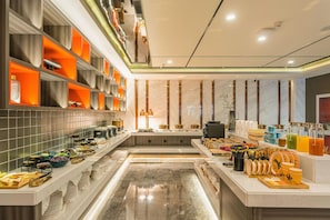 A modern hotel lobby with a long reception desk, a seating area, and a buffet with various food items and drinks. - Yaduo Hotel Beijing Zhongguancun Life Science Park (Beijing)