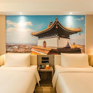 A hotel room with two beds, a view of a traditional building, and a small wooden nightstand with a phone and a cup.