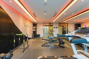 A modern gym with exercise equipment, a reception area, and a wall with the word 'TOURFIT'. - Yaduo Hotel Beijing Zhongguancun Life Science Park (Beijing)
