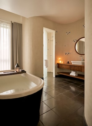 A modern bathroom with a freestanding bathtub, a vanity with a mirror, and a towel rack. - Anhill Boutique (Hue)