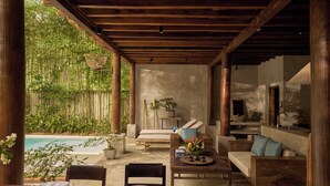 A covered outdoor area with a pool, wooden furniture, and potted plants. - Anhill Boutique (Hue)