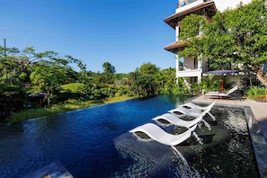 A swimming pool with tiered seating and a lush green landscape. - Anhill Boutique (Hue)