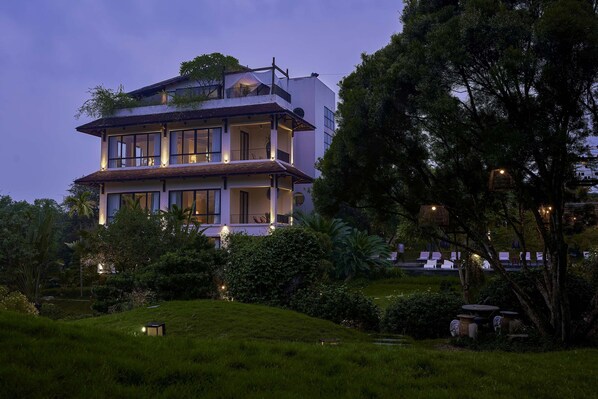 A multi-story building with balconies, surrounded by lush greenery and a well-maintained garden. - Anhill Boutique (Hue)