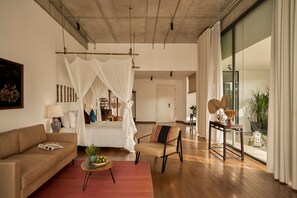 A room with a bed, a sofa, a coffee table, and a window with curtains. - Anhill Boutique (Hue)