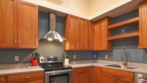 A kitchen with wooden cabinets, a stainless steel stove, and a sink. - Beautiful Farm Style House (Eugene)
