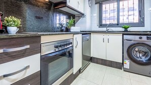 Eine moderne Küche mit Einbauofen, Geschirrspüler und Waschmaschine.