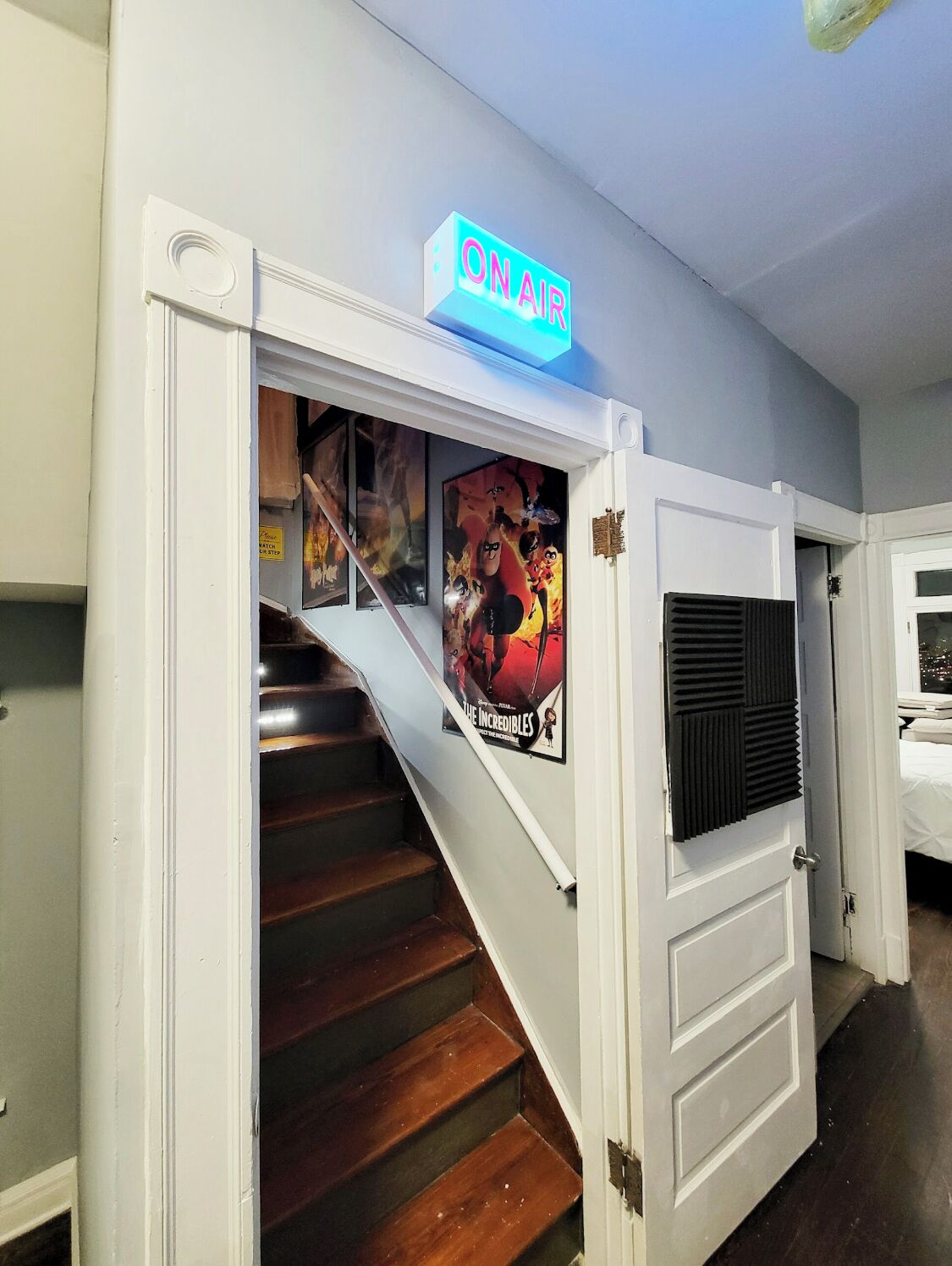 A staircase with a neon sign that reads "ON AIR" above it.