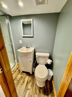 Ein Badezimmer mit Waschbecken, Toilette und Spiegel an der Wand.