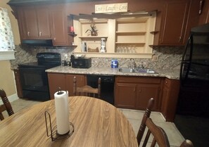 Enjoy cooking in this well-equipped kitchen with a stove, oven, and dishwasher, and dine at the adjacent table.