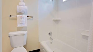 A bathroom with a toilet, a bathtub, and a shower. - Travelodge Aberdeen WA (Aberdeen)