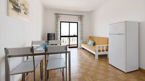 A modern kitchen with a dining table, chairs, a sofa, and a refrigerator. - Apartment 'Casa Atlântico nº2' close to the Sea with Shared Pool & Wi-Fi (Lagos)
