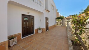 A building with a tiled patio, a door, and potted plants. - Apartment 'Casa Atlântico nº3' close to the Sea with Shared Pool & Wi-Fi (Lagos)