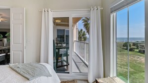 Un dormitorio con un amplio ventanal y balcón.