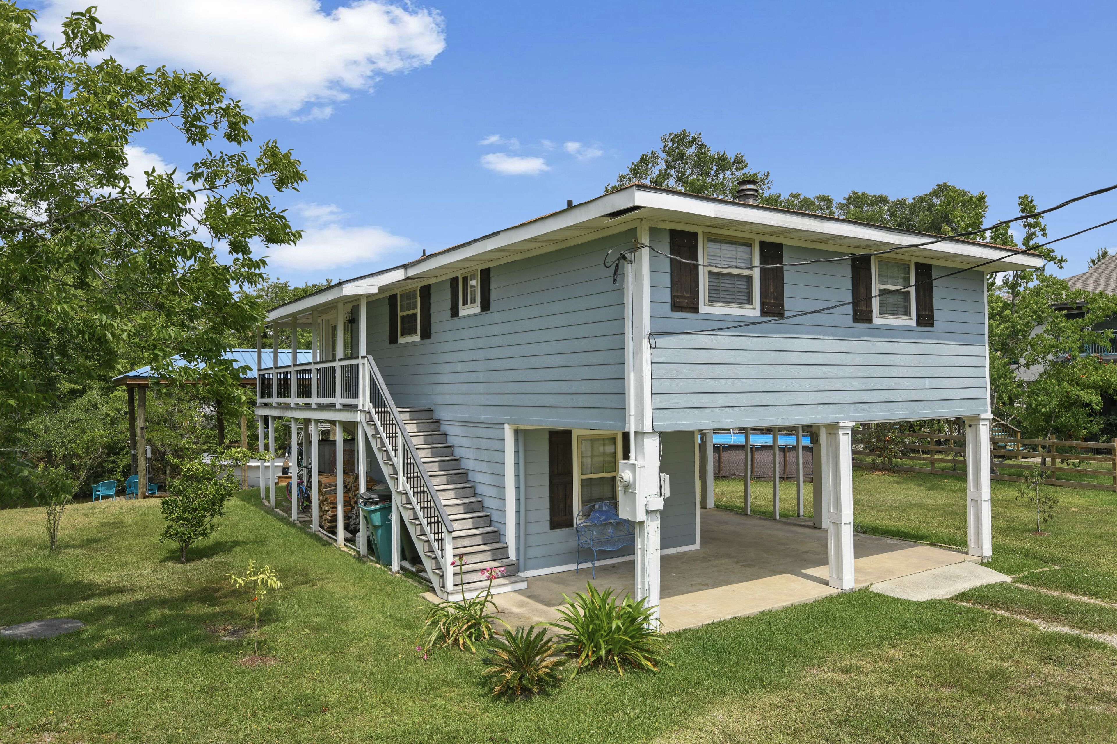 A two-story house with a covered porch and a staircase leading to the upper level.