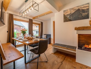 Un coin repas avec une table en bois, des chaises et une cheminée.